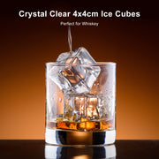 Glass of whiskey with crystal clear ice cubes on a dark background